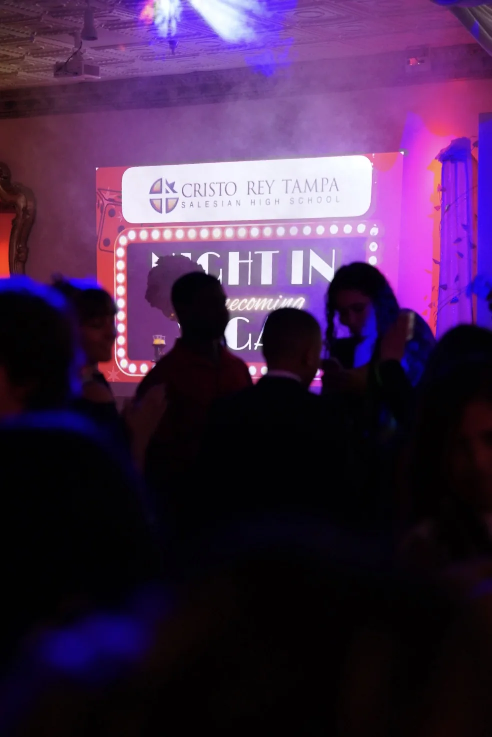 Event crowd silhouetted in violet light