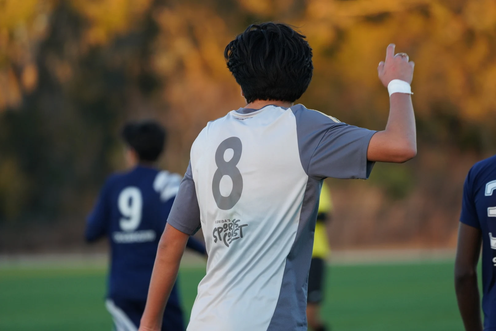 Number eight soccer player directing teammates in warm evening light
