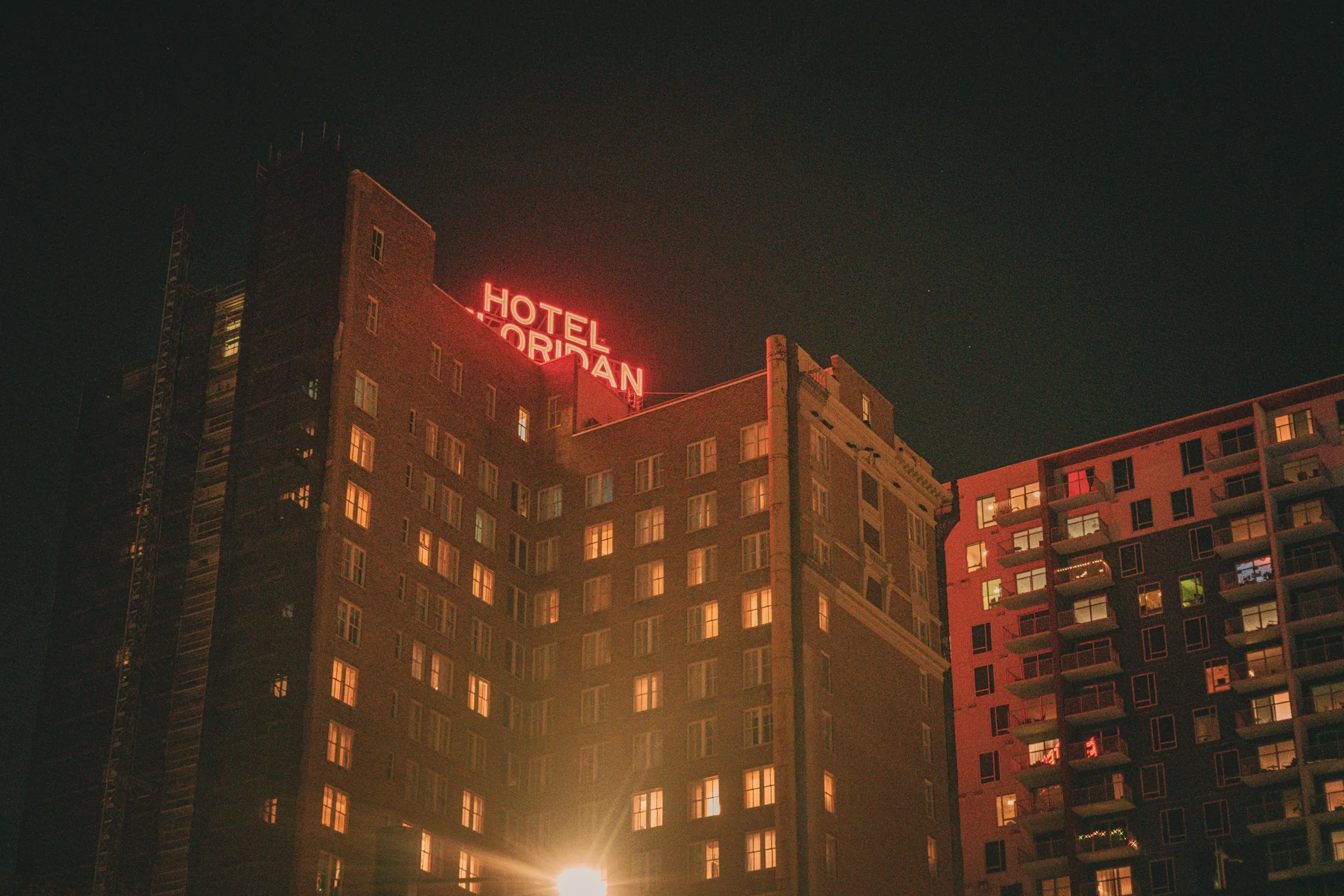 Hotel exterior glowing red against the night