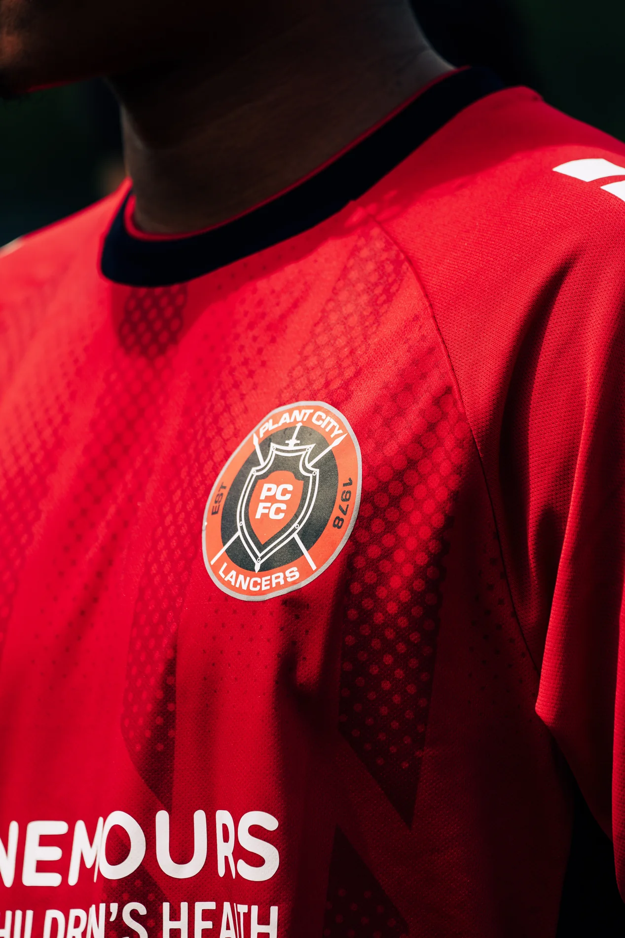 Close detail of a red soccer jersey and club crest