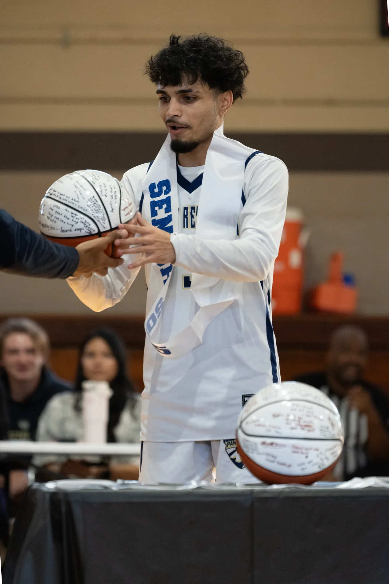 Basketball player presenting a signed ball