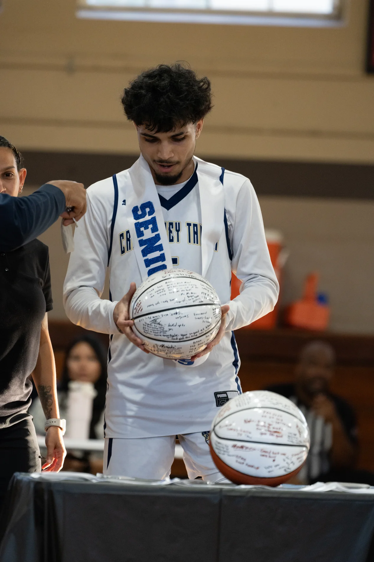 Basketball player holding a signed ball after the game